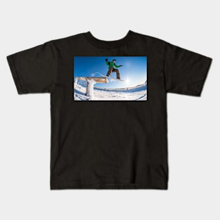 Snowboarder jumping against blue sky Kids T-Shirt